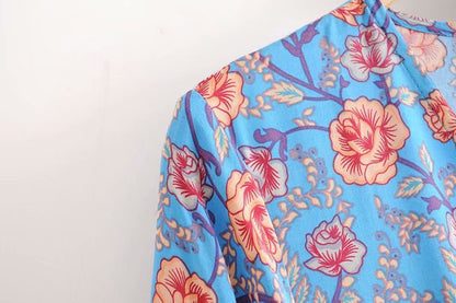 SÉRENE – Długa sukienka z dekoltem w serek i kwiatowym wzorem – Model kopertowy z paskiem w talii